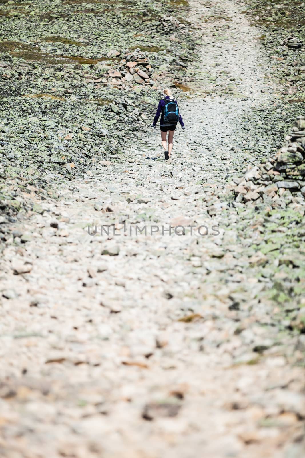 Young Woman Walking on a Rocky Hiking Path