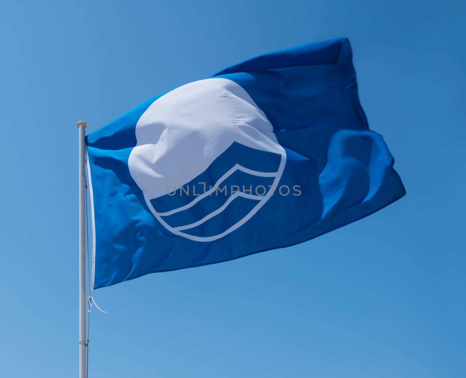 Blue flag on beach. Cala Estancia, Mallorca, Balearic islands, Spain in July.
