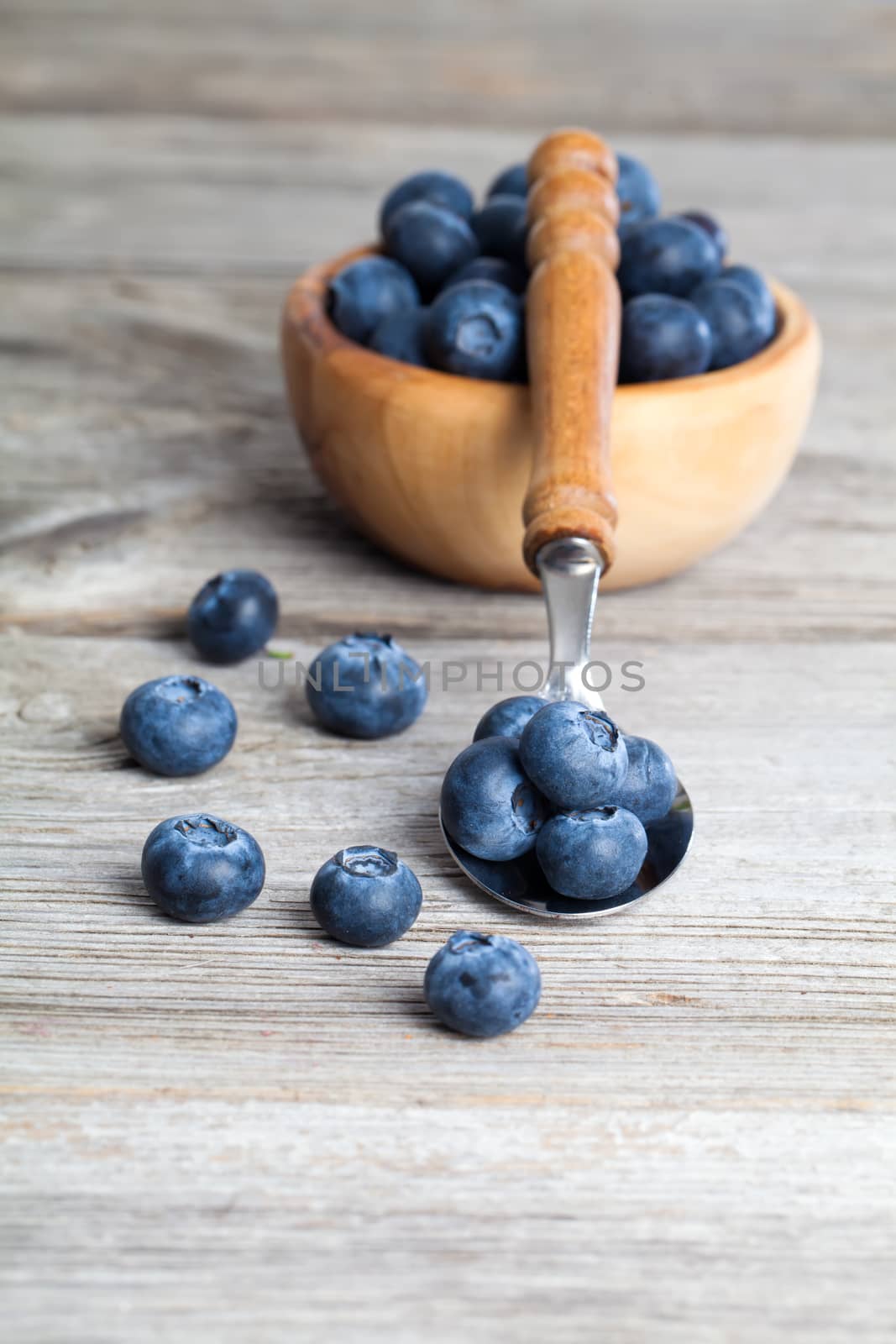 Blueberries on a wooden spoon by motorolka