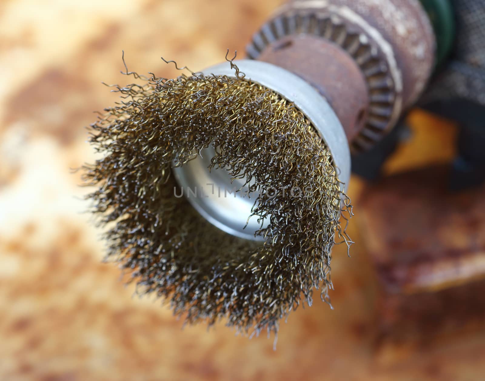 drill fitted with a wire brush close up shallow dof