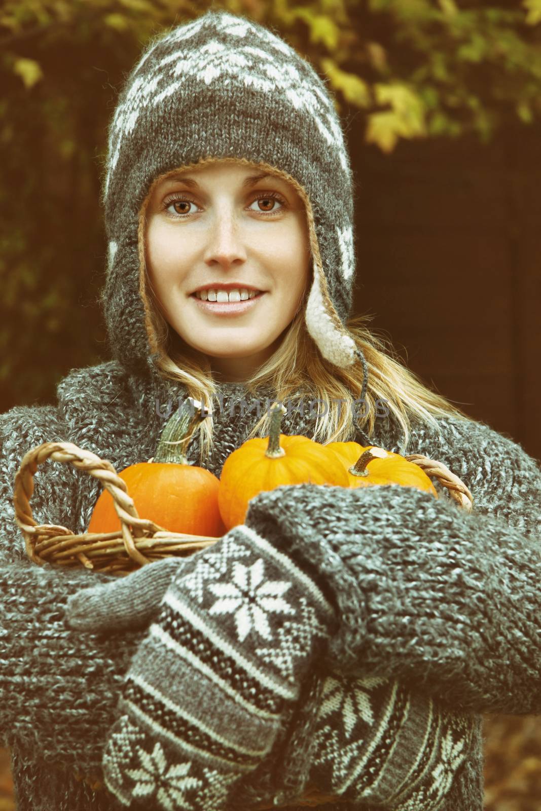 Young woman holding a basket of pumpkins  by Sandralise