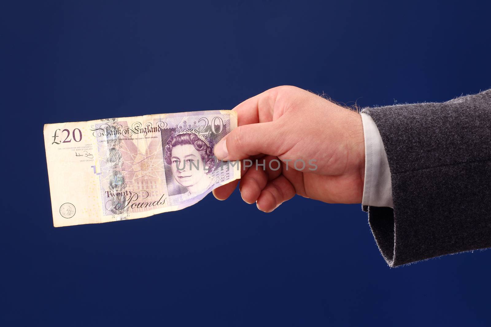 male hand holding a twenty British pounds