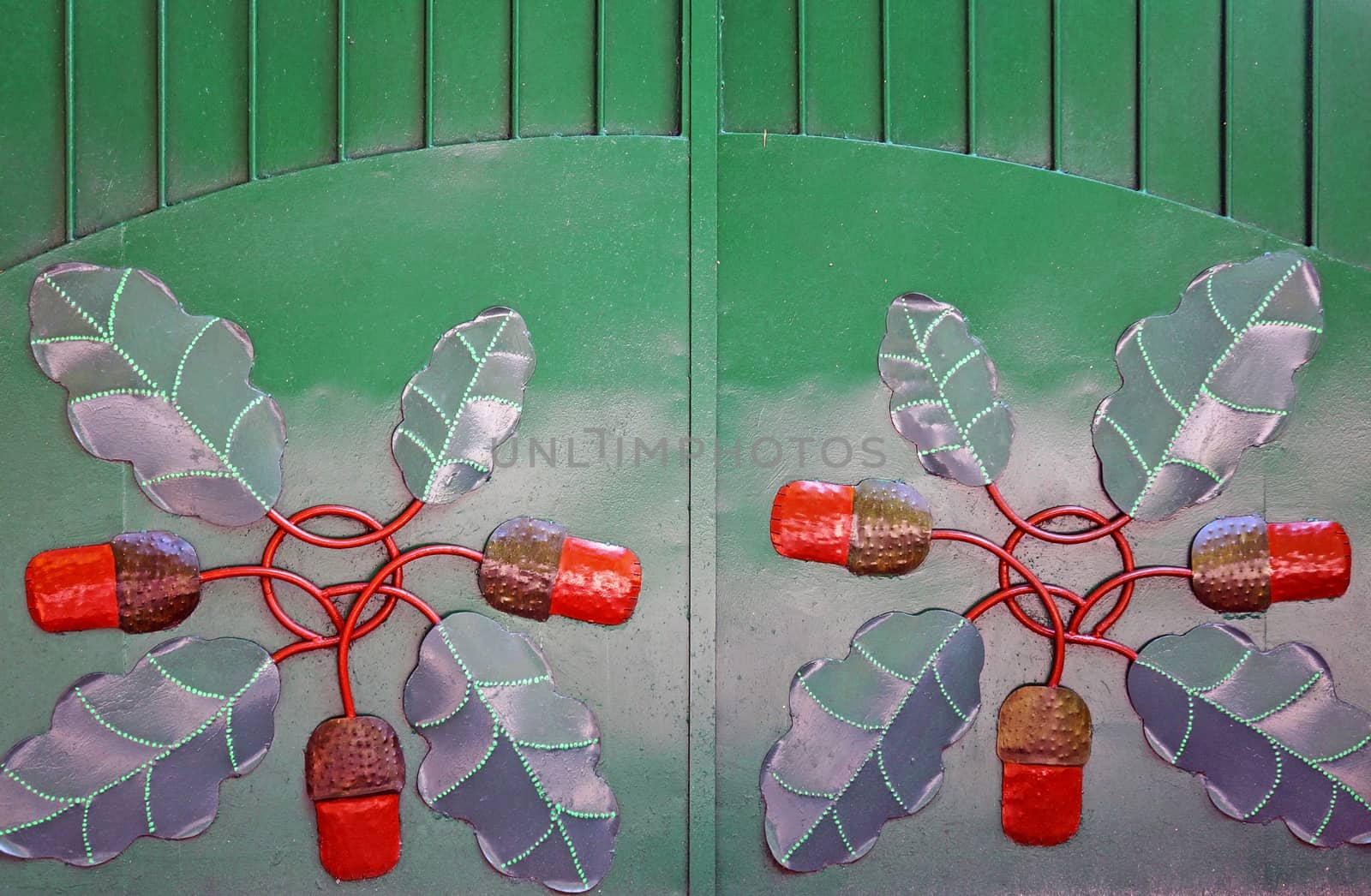 Green metal gate with forged pattern in the form of acorns