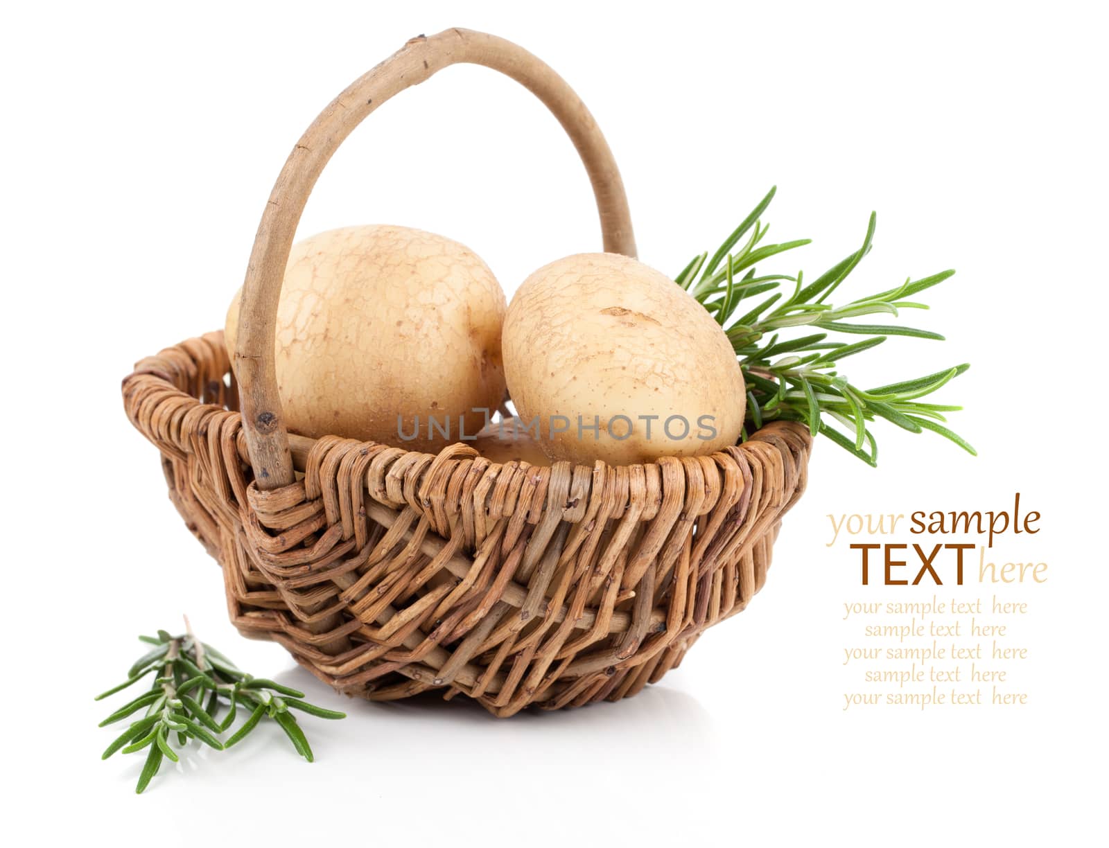 Golden Potatoes in wicker basket, with rosemary over white background