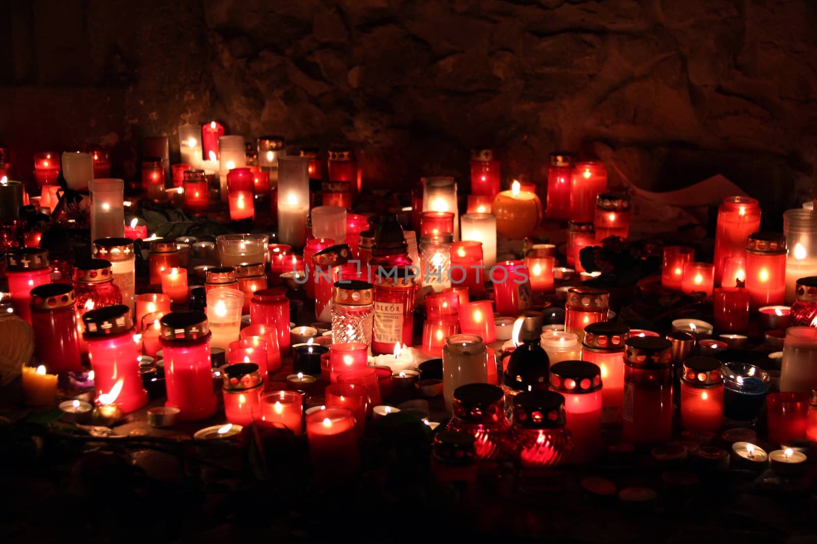 Photo shows a group of red candles at night.