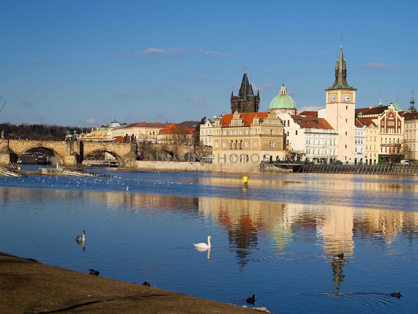 Photo shows various historical houses, Vltava river, bridges and other architectural details.