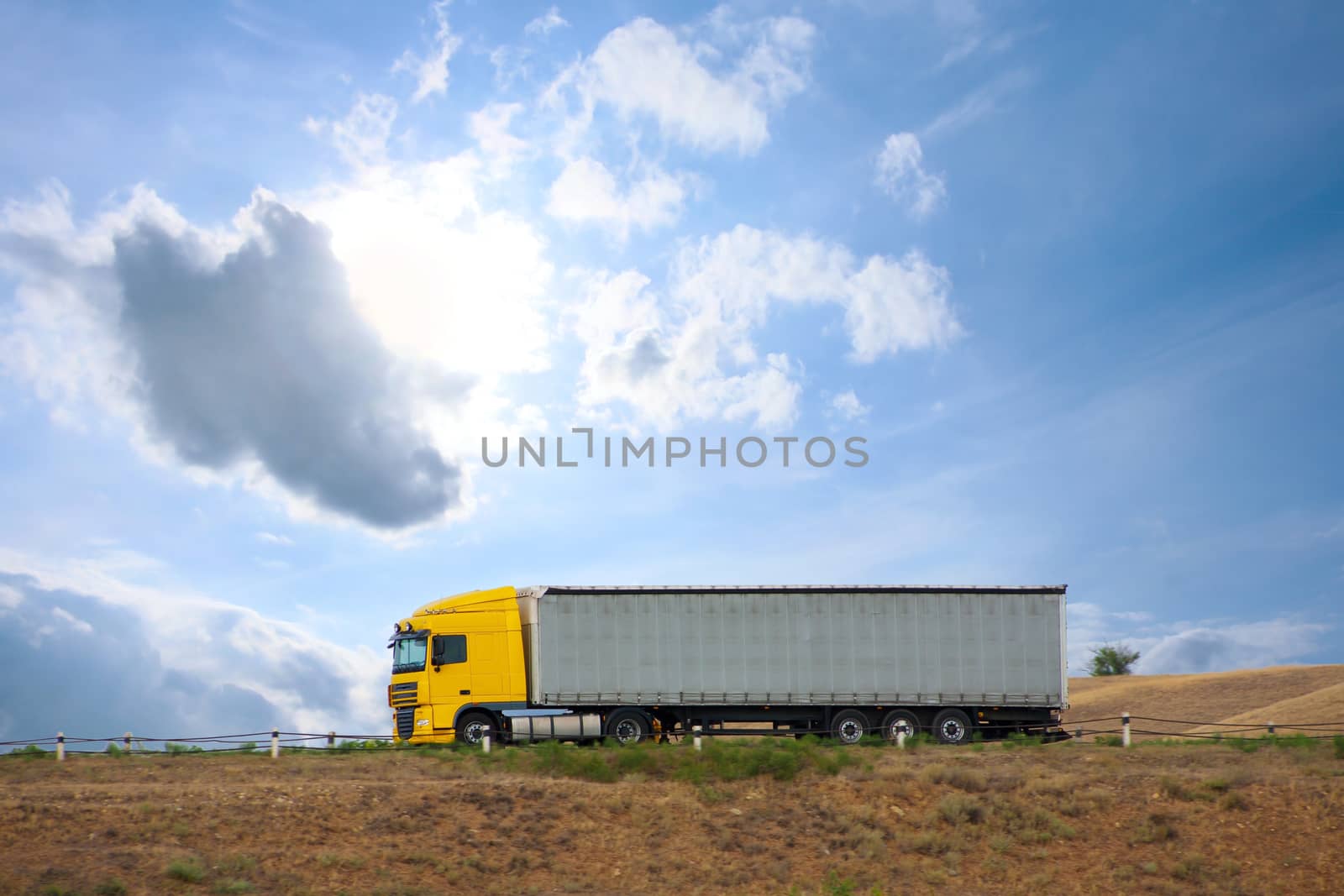 big auto truck goes on the way to sky background
