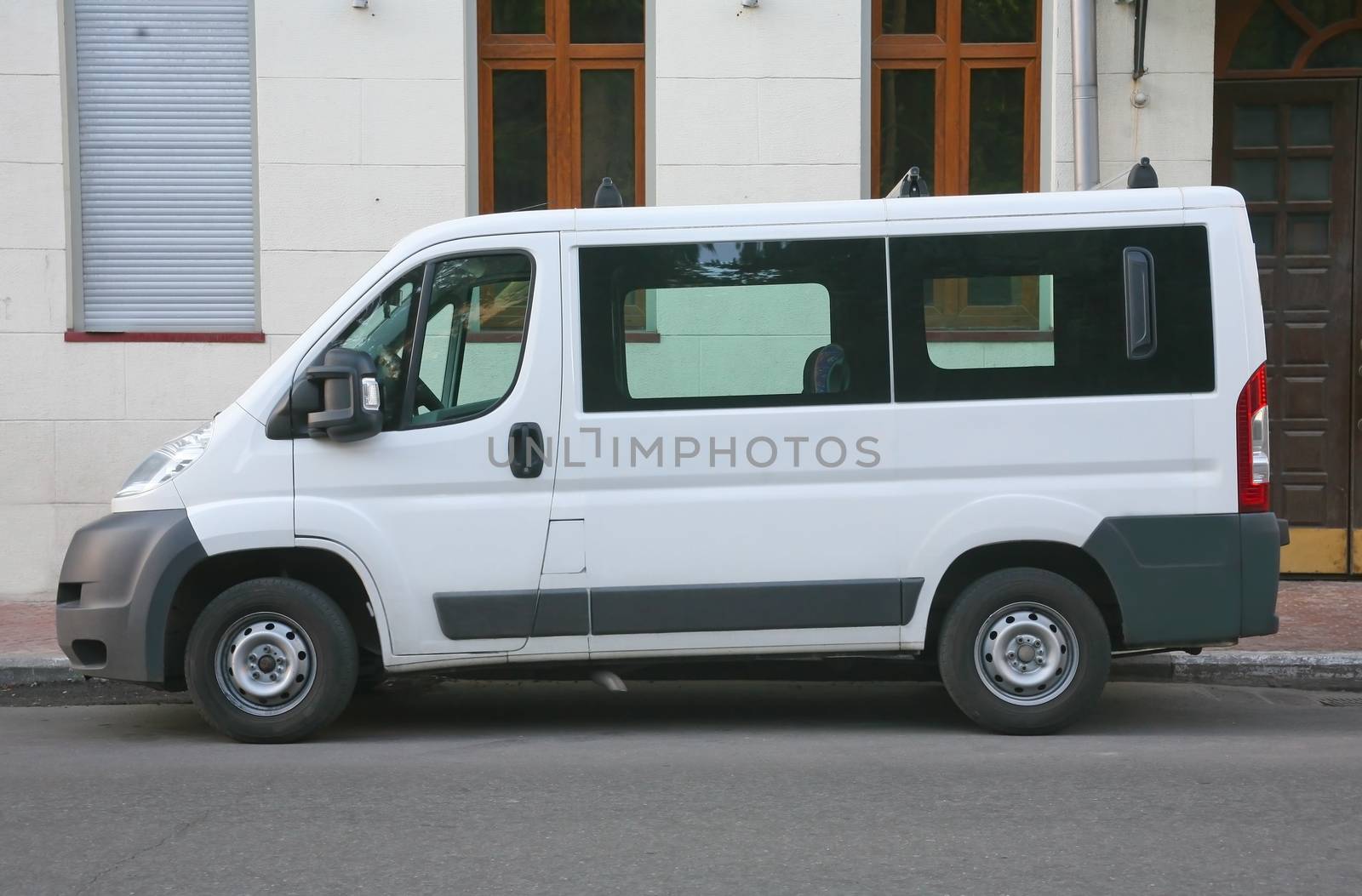 white minibus is parked in city street