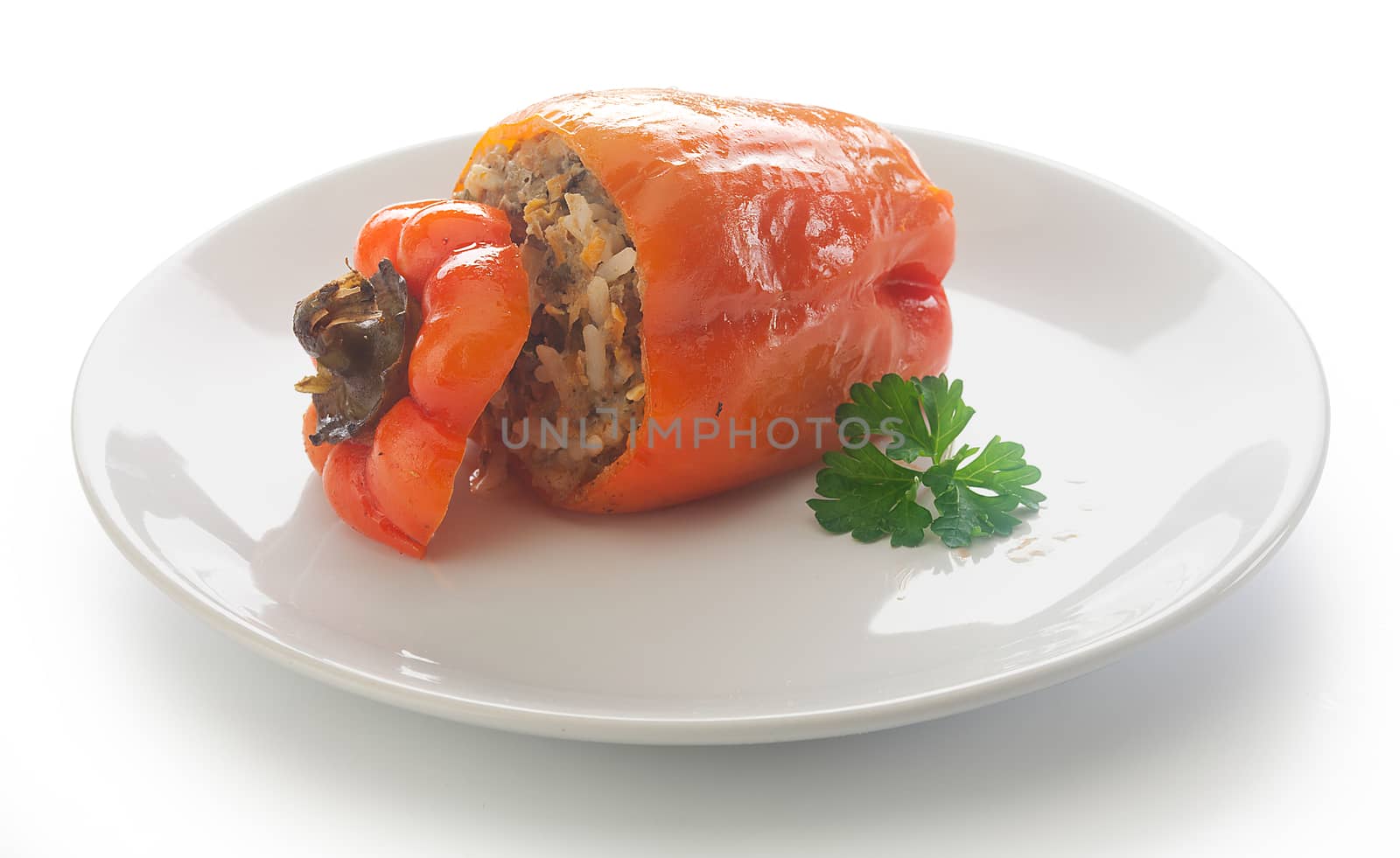 One stuffed red pepper with fresh parsley on the white plate