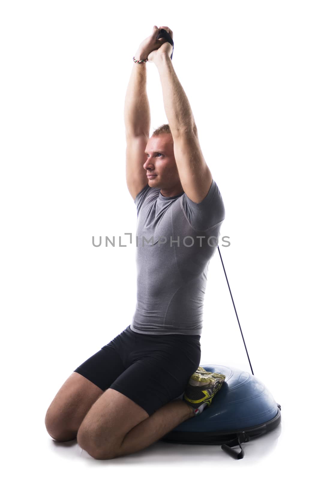 Sexy muscular man, working out with elastics, isolated on white