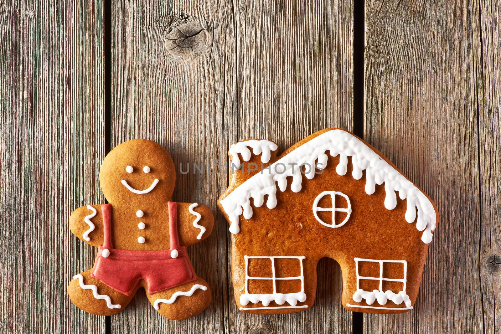 Christmas homemade gingerbread man and house on wooden table