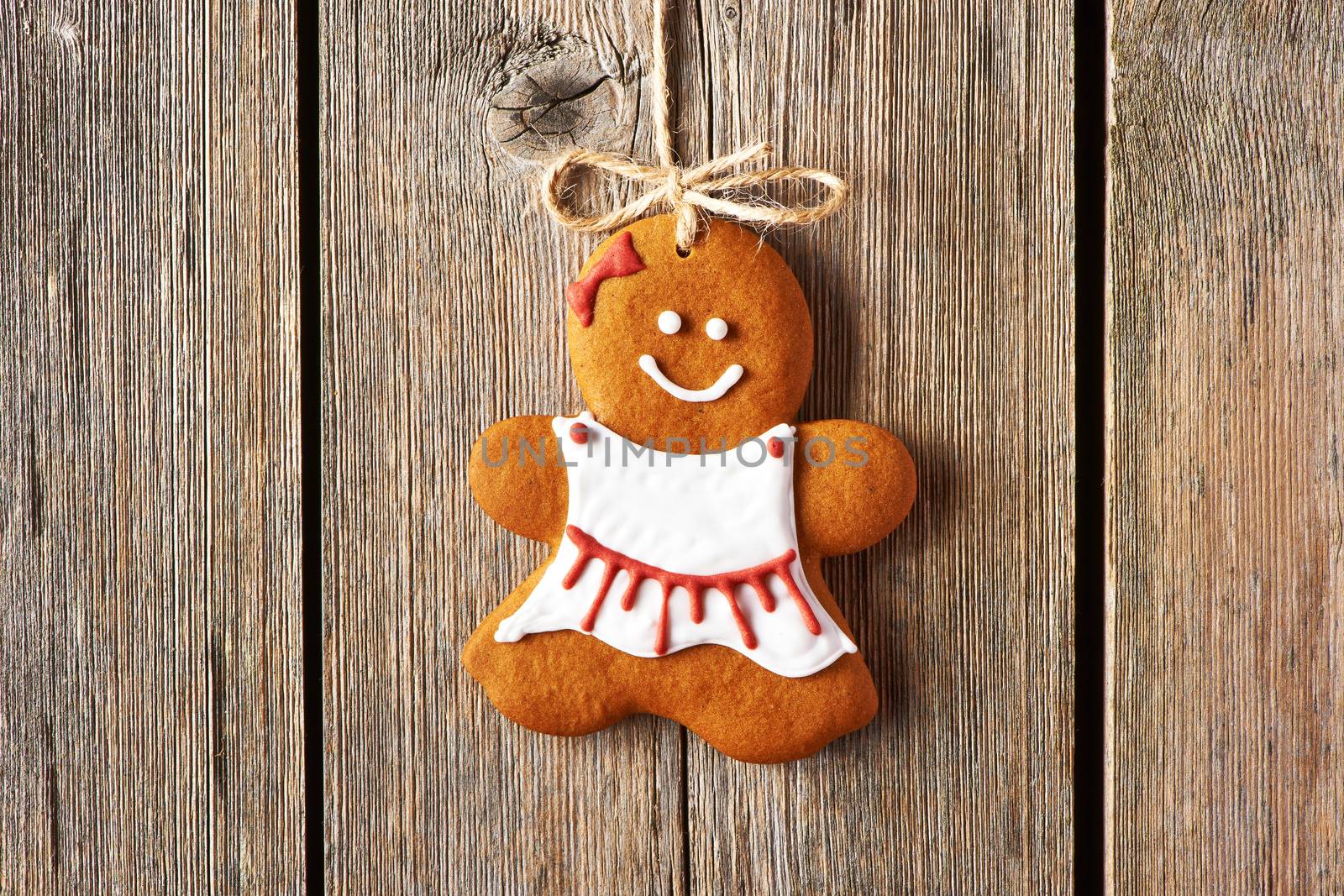 Christmas homemade gingerbread girl over wooden background