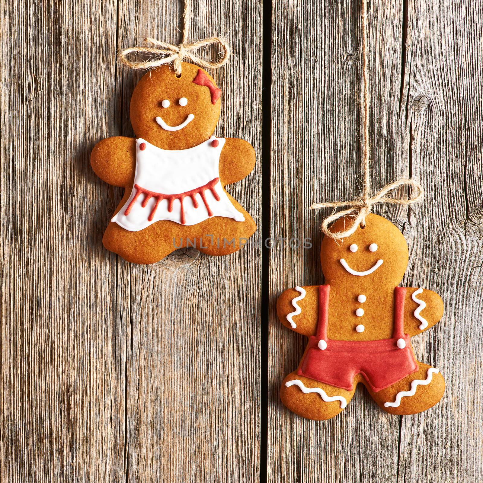 Christmas homemade gingerbread couple cookies over wooden background