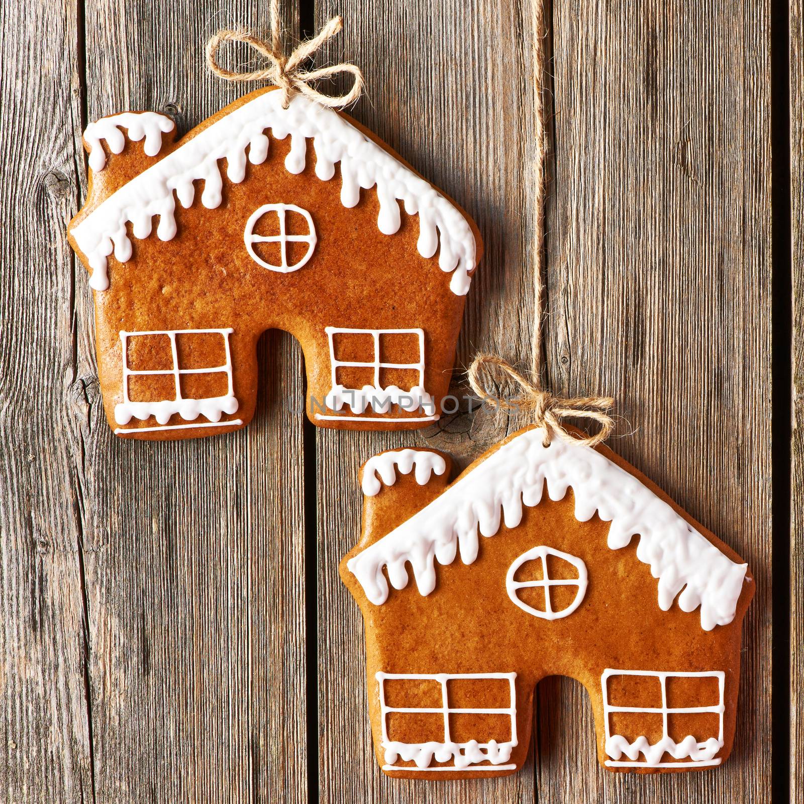 Christmas homemade gingerbread house cookies over wooden background