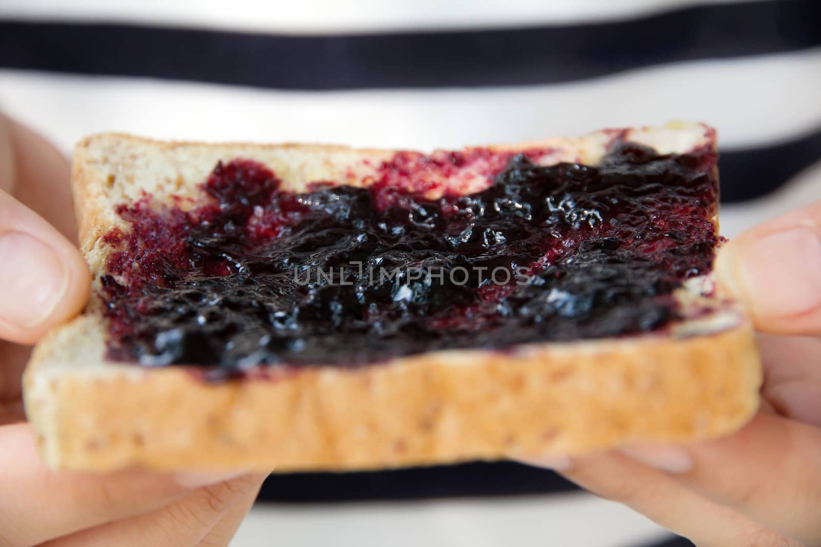 hand holding grape jelly sandwich Close up