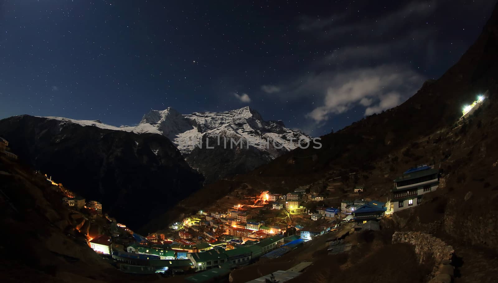 Night sky and stars passing by behind mountain Kongde Ri, Namche Bazaar village. Nepal
