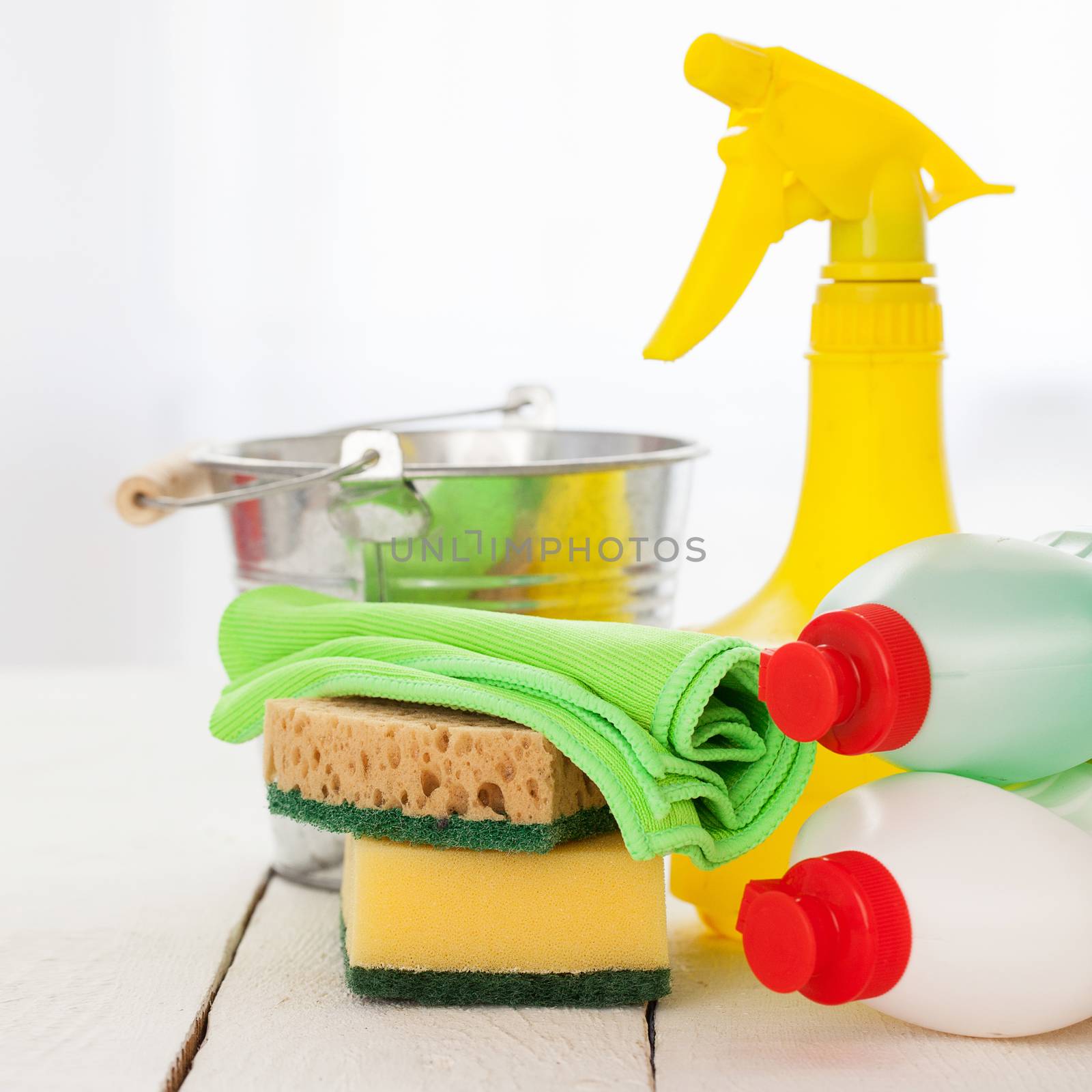 Bright colorful cleaning set on a white wooden table