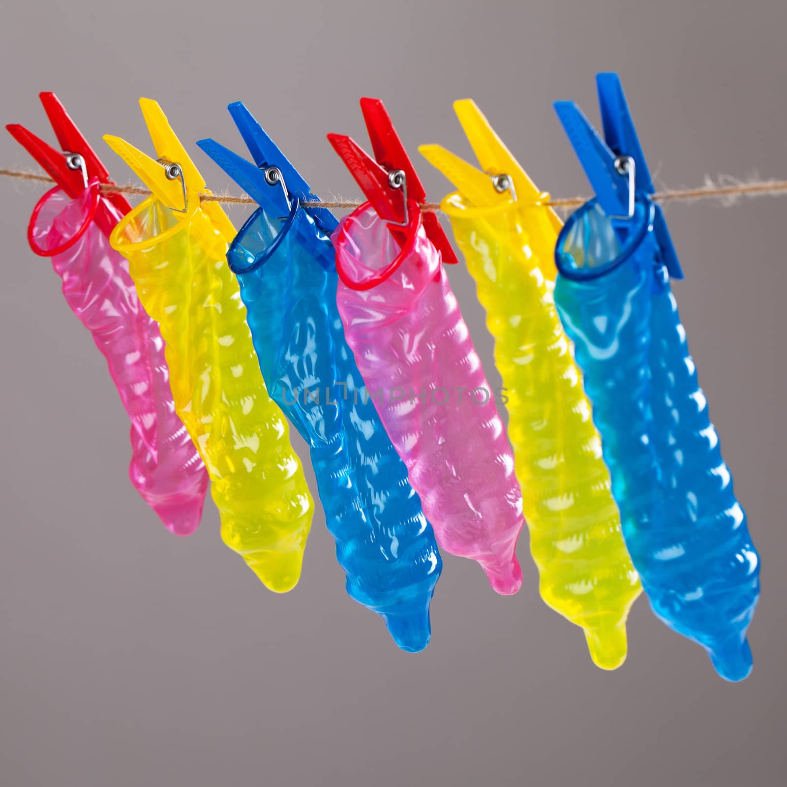 Colorful condoms with clothespins on a rope
