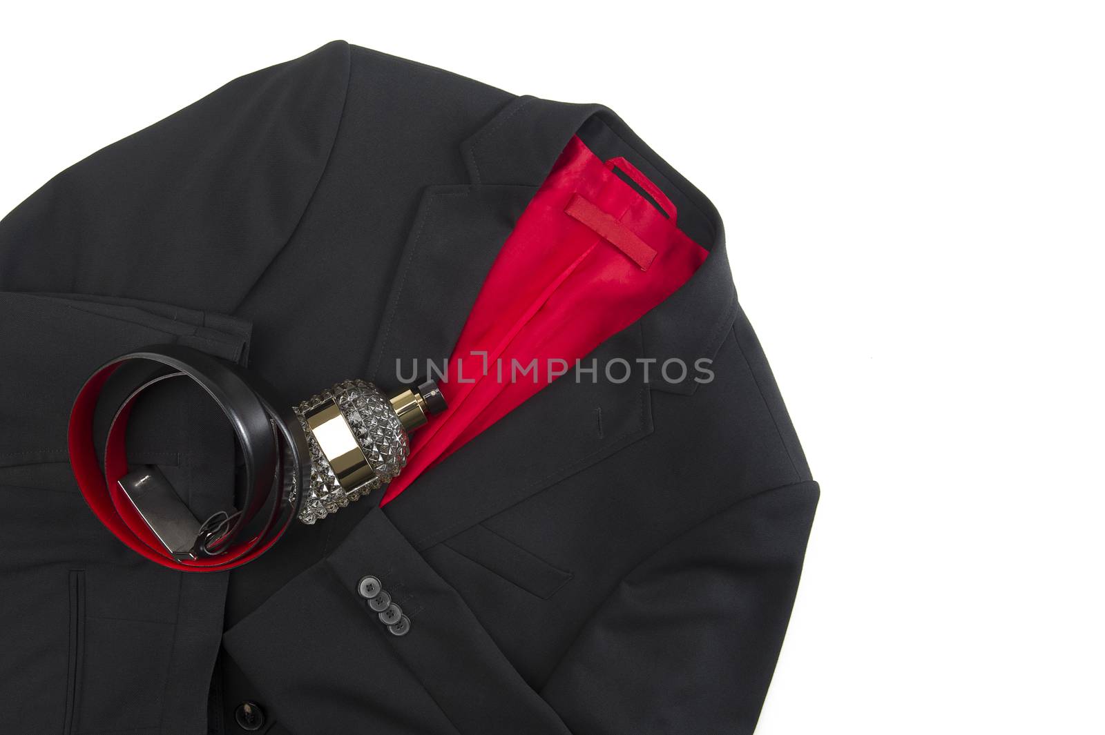 Stylish mens black or dark grey jacket with a colorful crimson lining and matching leather belt lying on a white background with a glass toiletry bottle, overhead view with copyspace