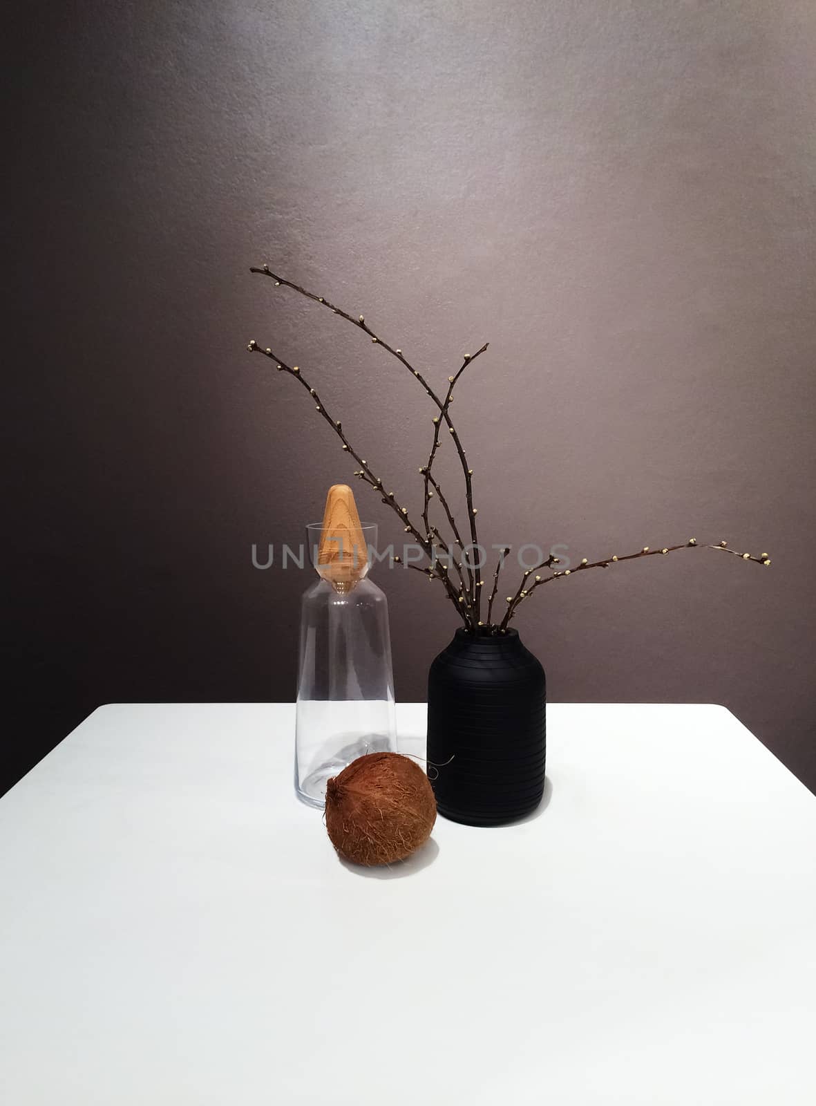 Vase with tree branches and decorative objects on the table.