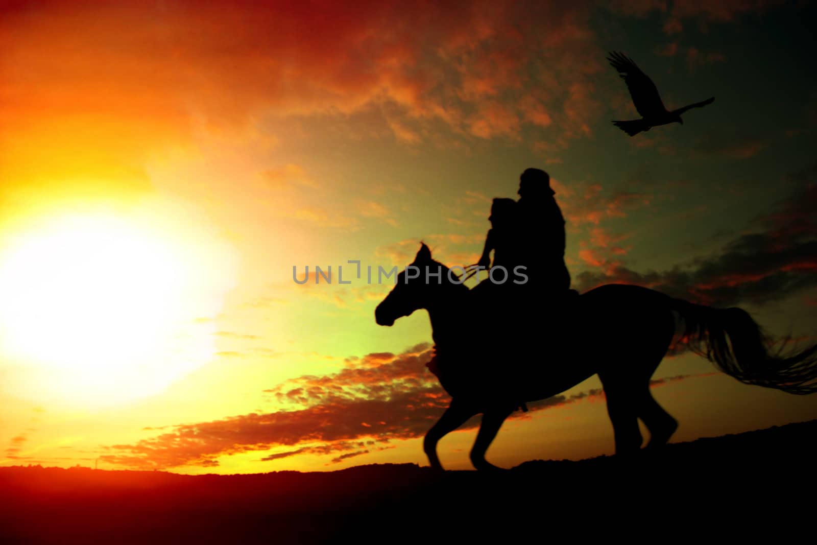 A silhouette of a father and daughter riding home on their horse in the evening