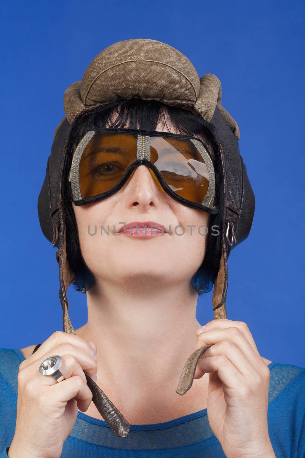 woman with an old army tank personal helmet- isolated on blue