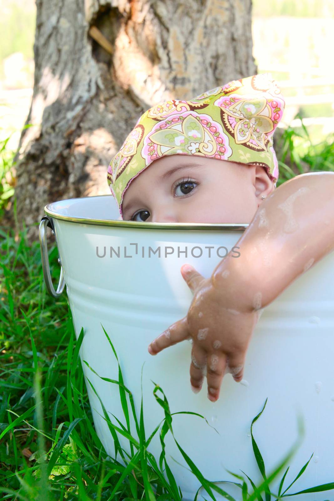 Beautiful baby girl having a bath outdoors 