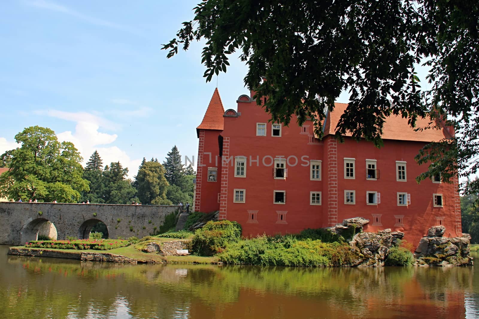 Photo shows red castle house and its surroundings.