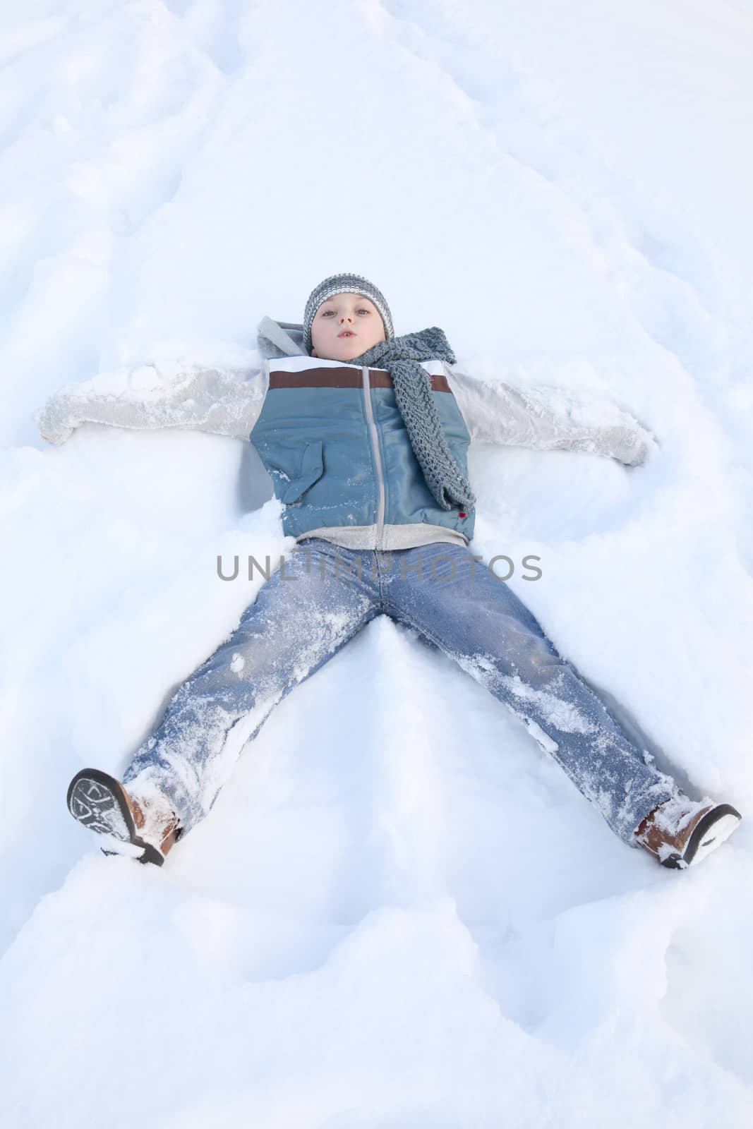 Young boy outside in the snow wearing blue