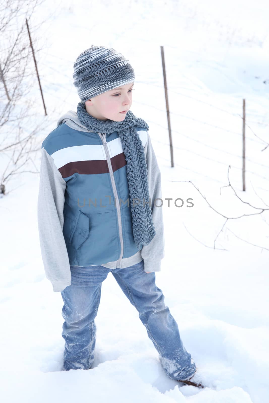 Young boy outside in the snow wearing blue