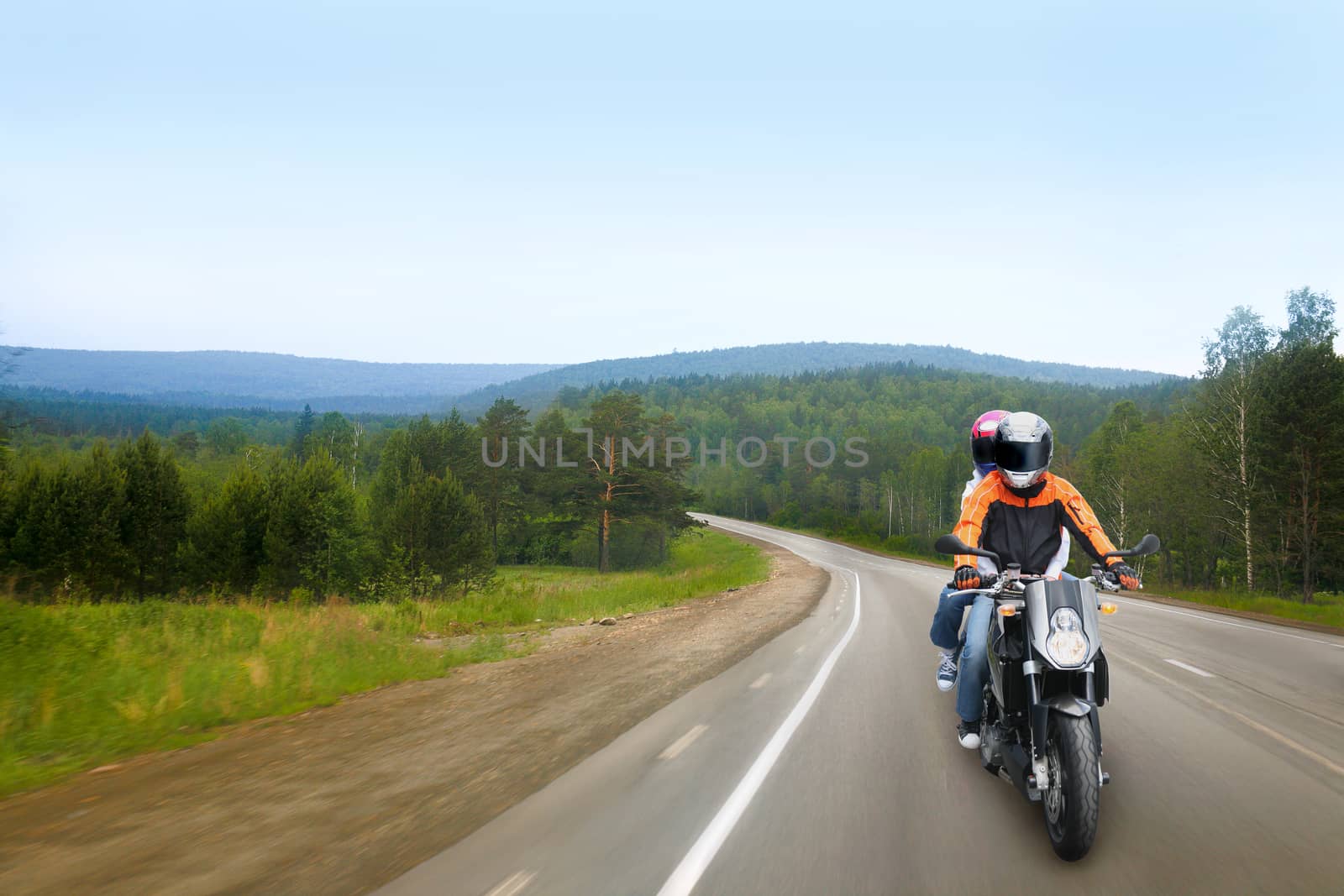 motorcyclist and passenger go on country road