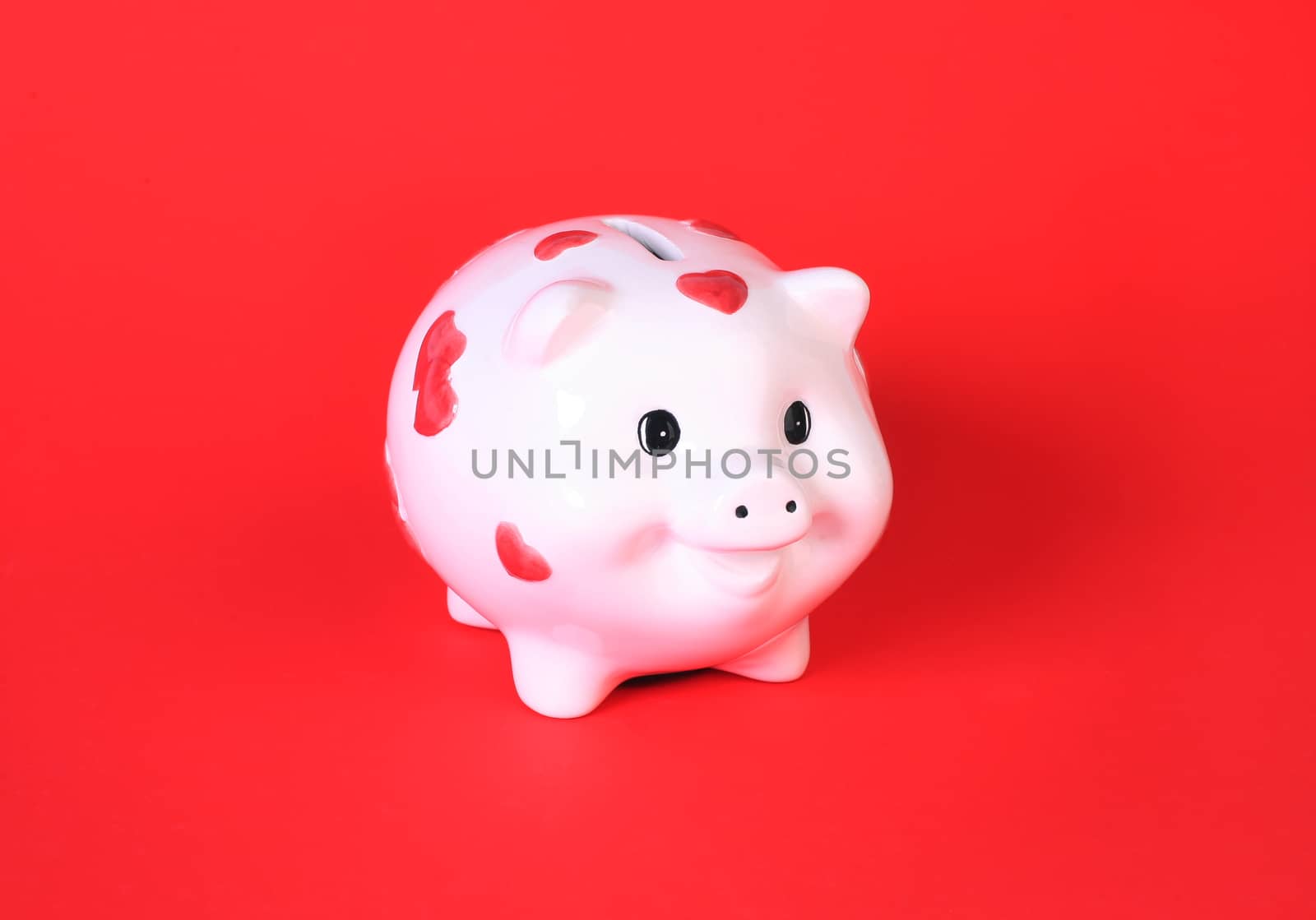 White pig-coin box on red background