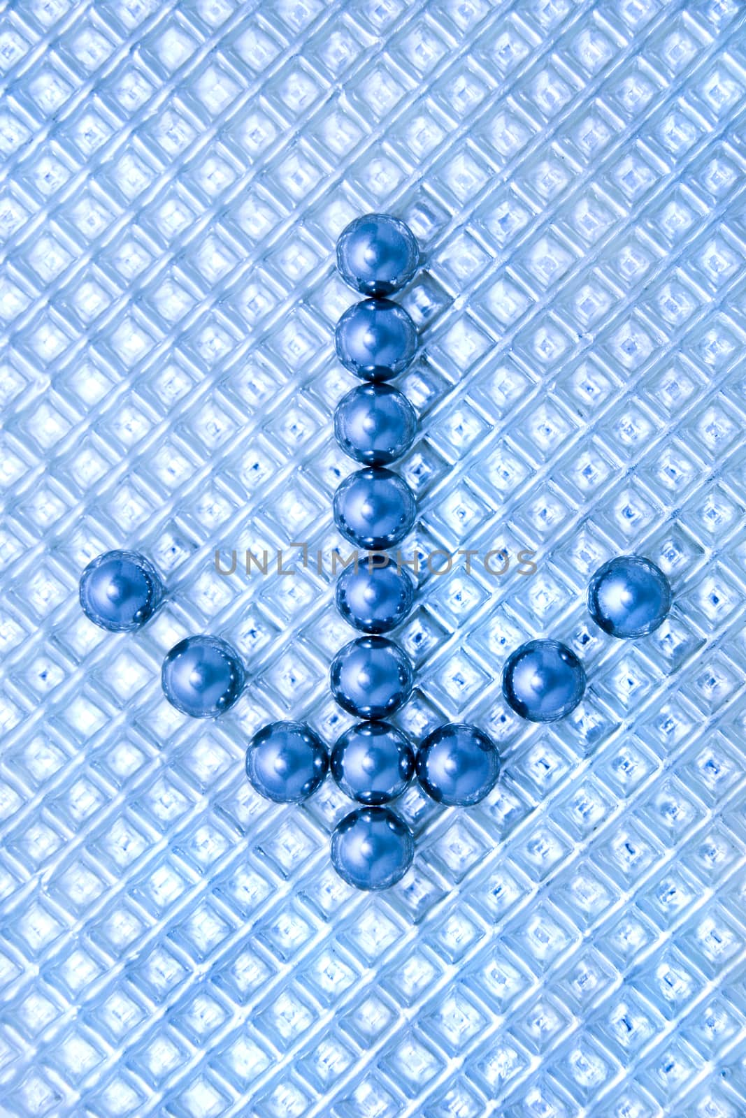 Arrow from steel balls on a plastic textural background