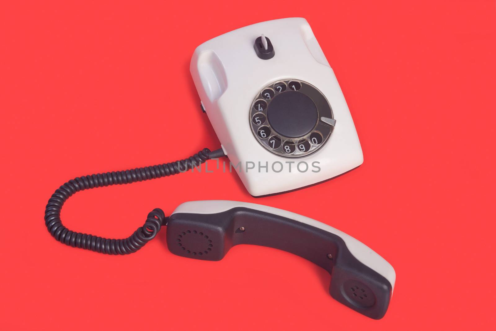 White rotational phone on red background