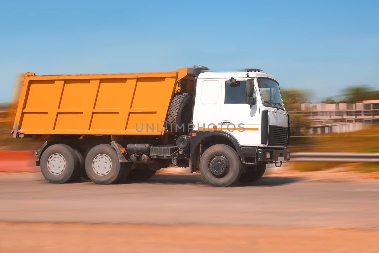 big powerful dump truck goes on road