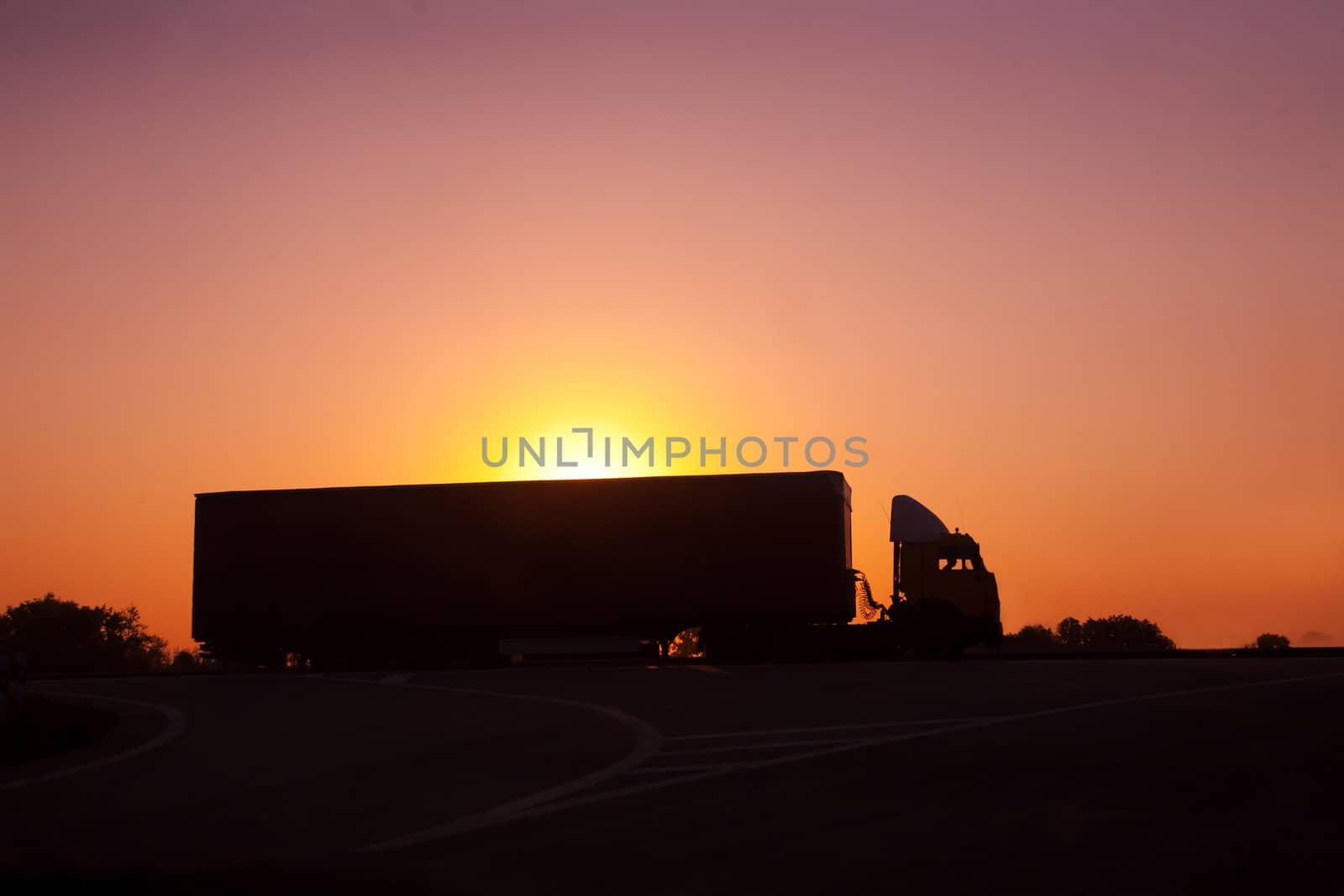 railer goes on  motorway against sunset by yurii_bizgaimer
