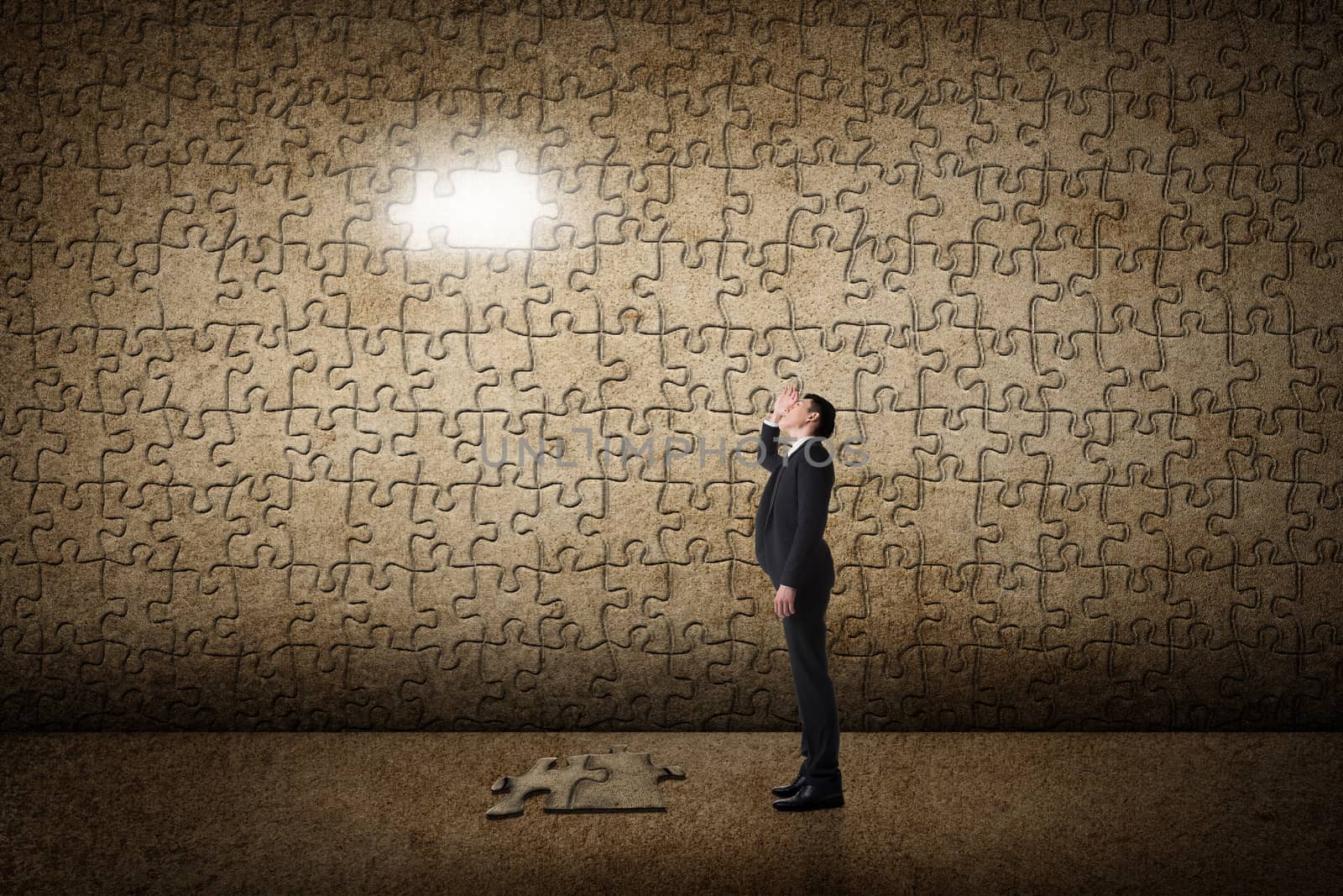 Asian man standing in front of a puzzle wall. Concept of mystery, problem, solution.