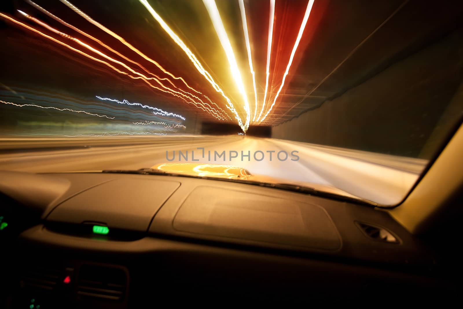 Car goes on  night city in  tunnel