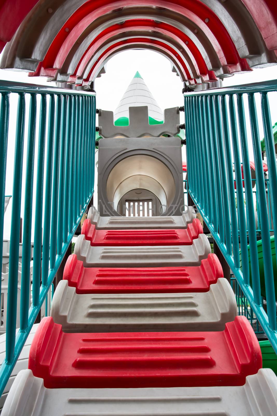 the playing in the red plastic tunnel slide at the fun park