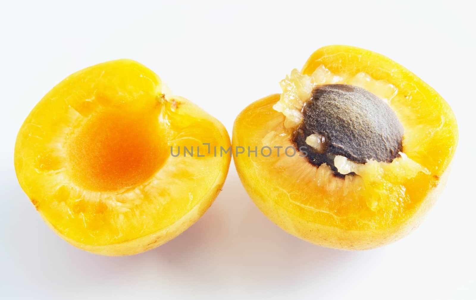 Close up of a ripe apricot fruit cut into half with the stone
