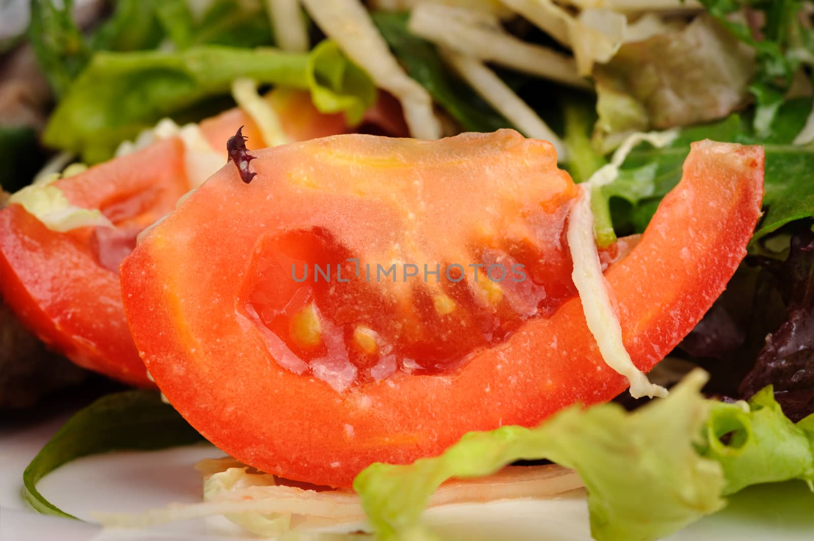 Fresh vegetable salad, macro closeup of tomato slice