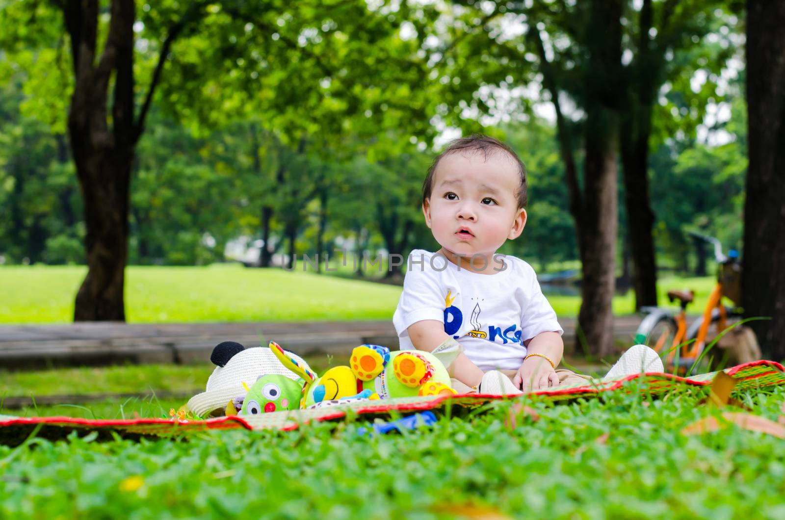 Asian baby sitting in park.