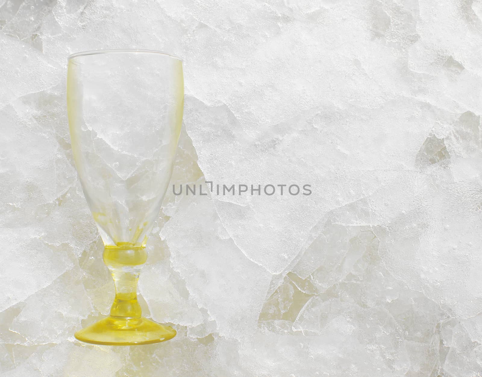 Still life with an empty wine glass lying on slabs or shard of thin ice, with copyspace. Ideal for bar and drink related advertisements or for brochures and even bar menu background.
