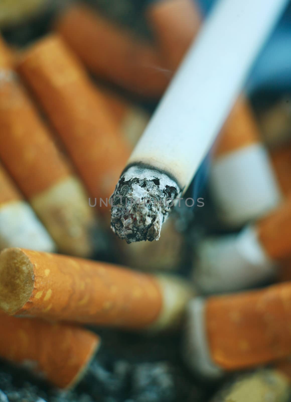 Smoking cigarette against set of stubs