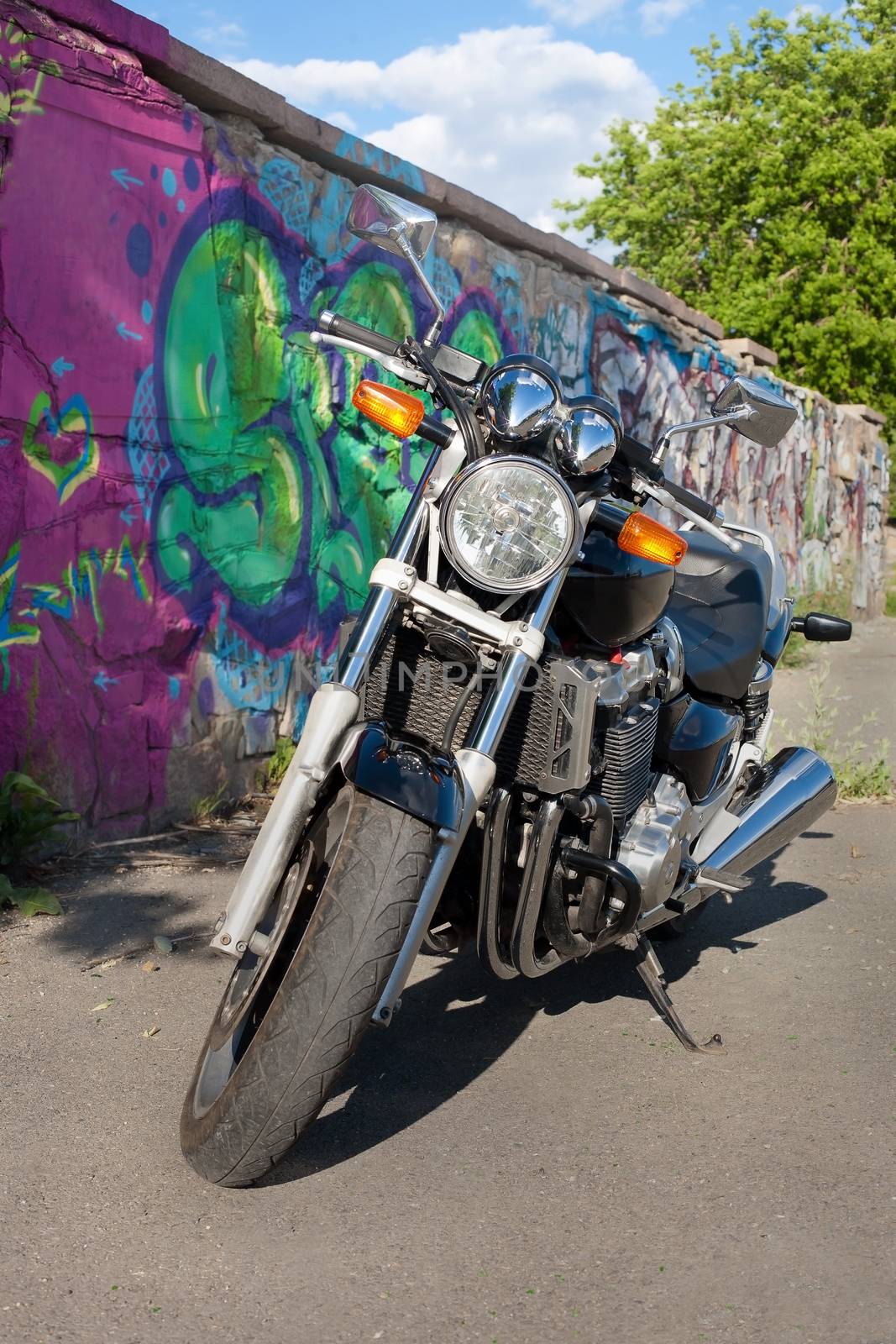 big black motorcycle at  wall with drawing 