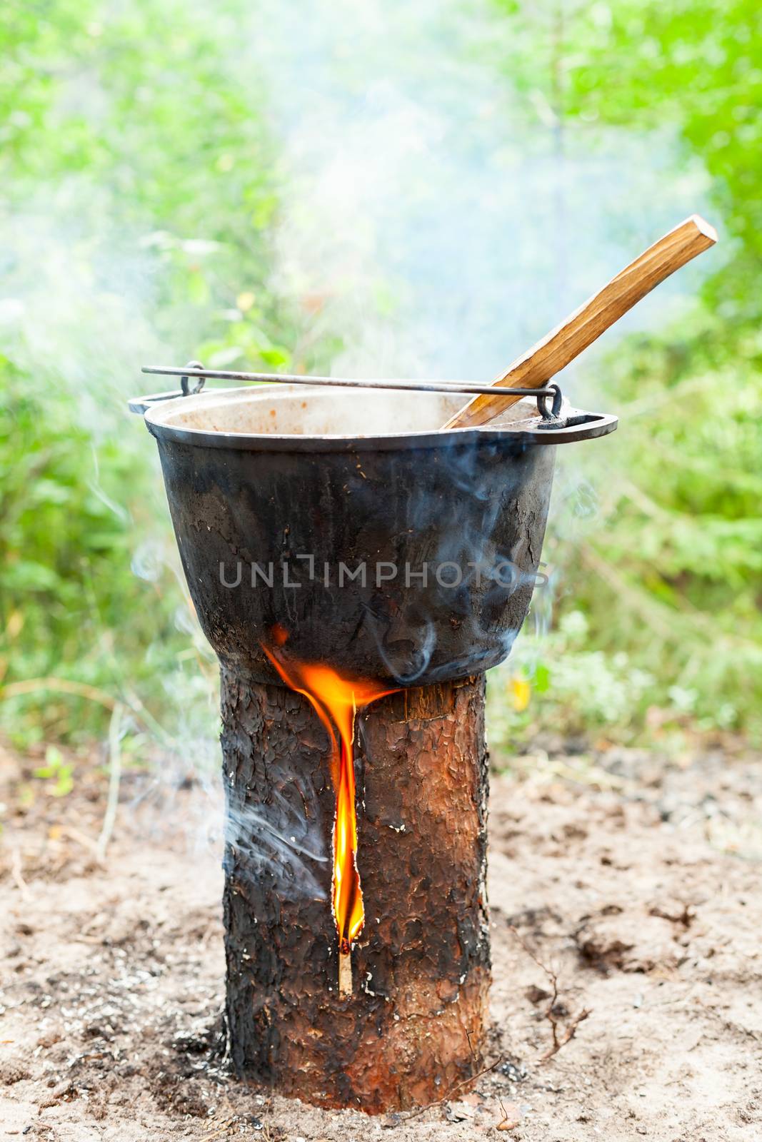 Cooking Goulash soup in cauldron on Finnish (Swedish) log stove