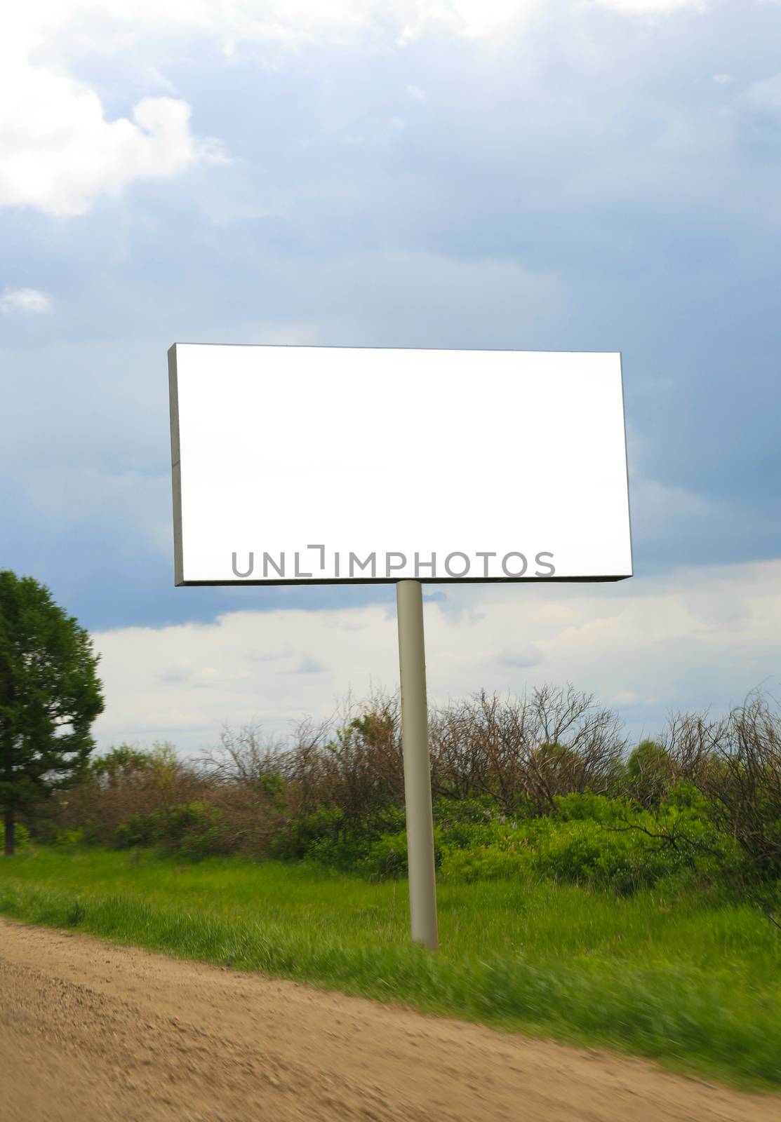 White rectangular billboard near road against the sky.