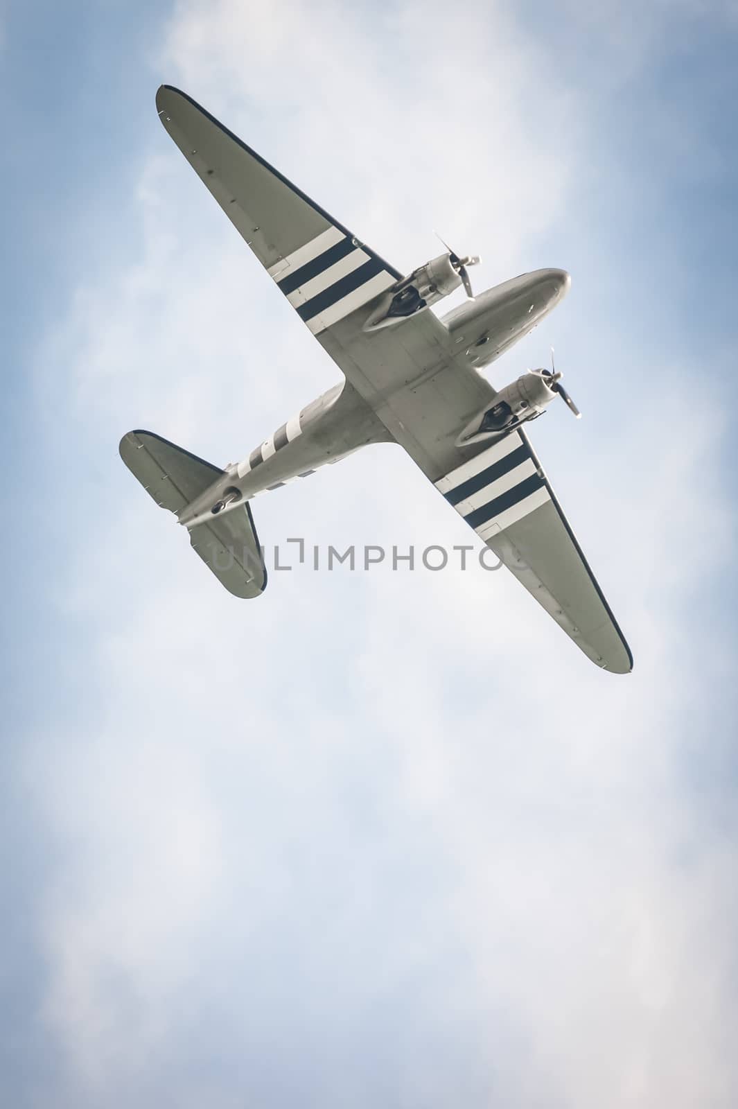 vintage transporter aircraft against a blue cloudy sky
