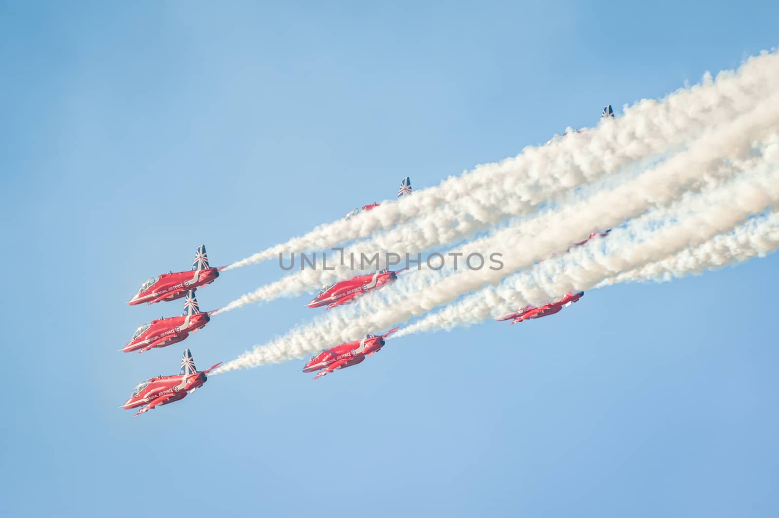 Farnborough, UK - July 18, 2014: The Red Arrows formation aerobatic display team leaving smoke trails in the sky over Farnborough, UK