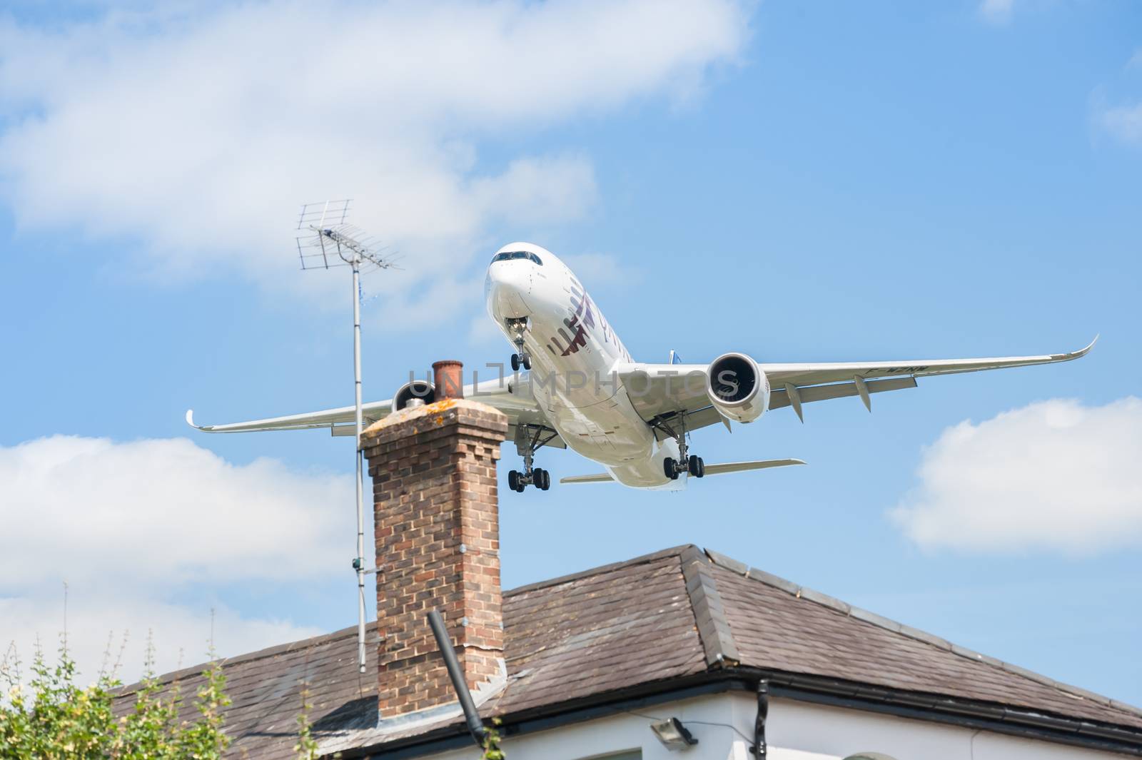 Farnborough, UK - July 14, 2014: Qatar Airways Airbus A350 on landing approach over rooftops to participate at the Farnborough Airshow,  UK
